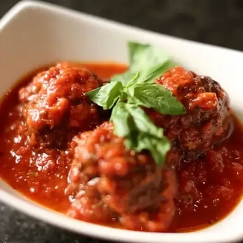 Meatballs in tomato sauce topped with fresh basil