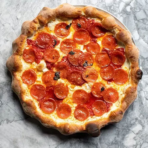 A pepperoni pizza on a marble counter