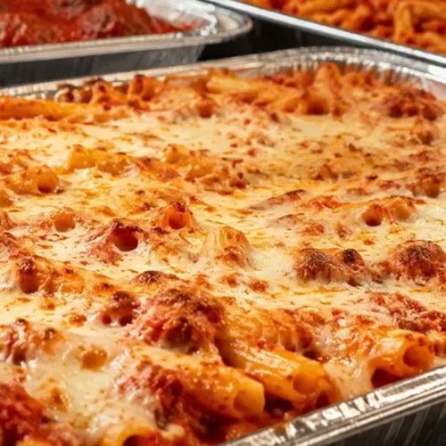 A tray of baked ziti with melted cheese