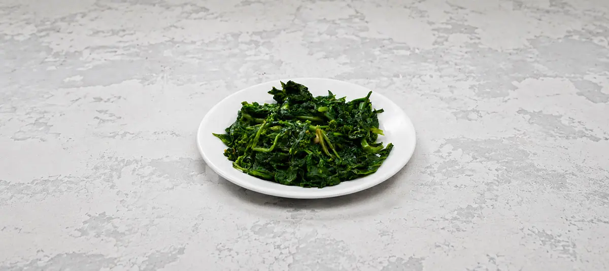 Sautéed broccoli rabe on a small white plate