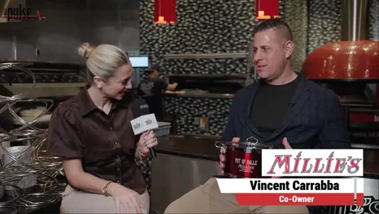 Reporter interviewing co-owner Vincent Carrabba inside Millie’s Old World