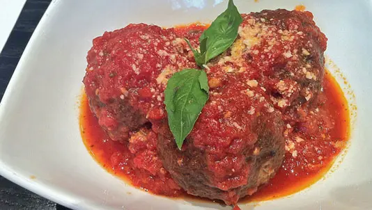 Meatballs in tomato sauce with basil and grated cheese