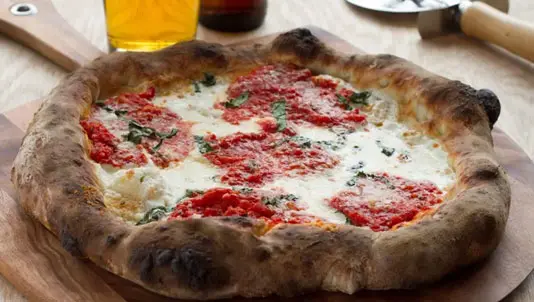 Pizza topped with tomato, fresh mozzarella and basil